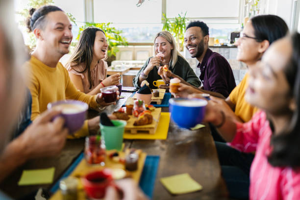 Multiracial people gathering together while having breakfast on rooftop cafe stock photo
