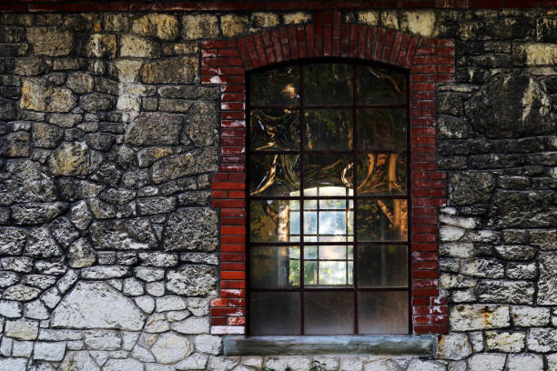 An old translucent window in a vacant building with stone wall