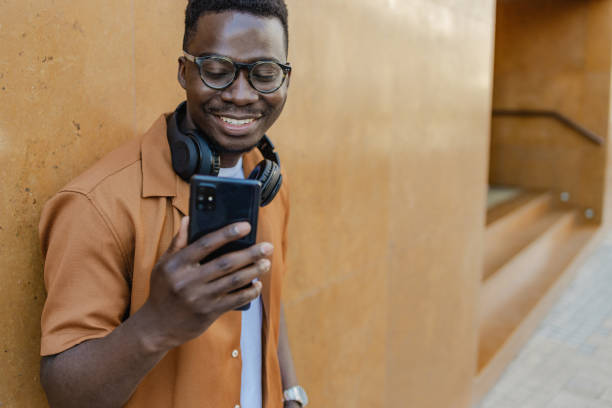 istock Confident young man chatting on the phone against orange background 1386971921