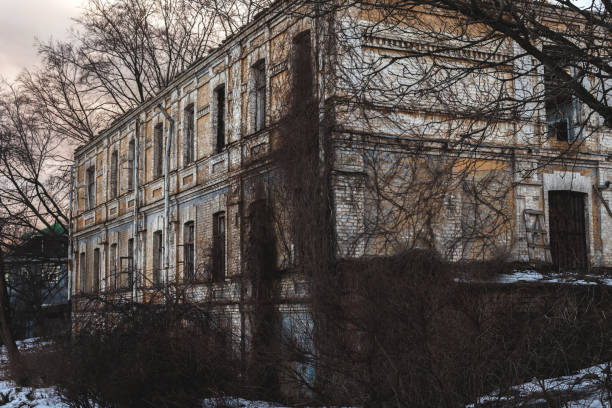 istock Dark broken windows in an abandoned house. Old ruined brick house 1386972895