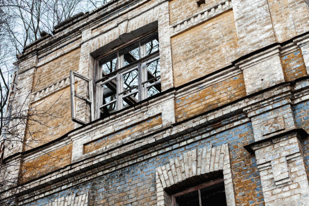 istock Dark broken windows in an abandoned house. Old ruined brick house 1386972957