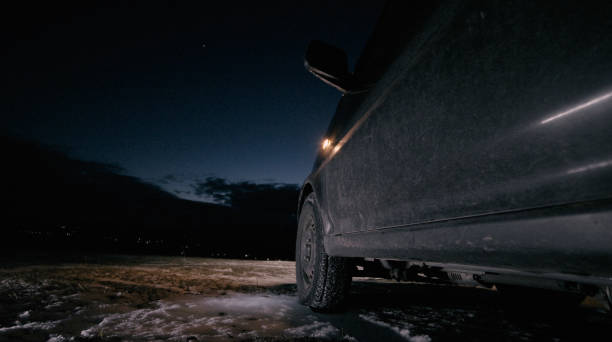 istock Man changing car tyre at night on winter road. 1386973577
