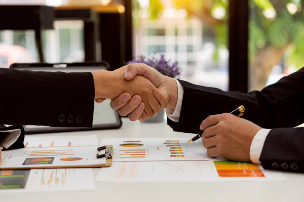 Young businessmen shaking hands in the office Completing a successful meeting group of business people in modern office teamwork in cooperation and handshake stock photo