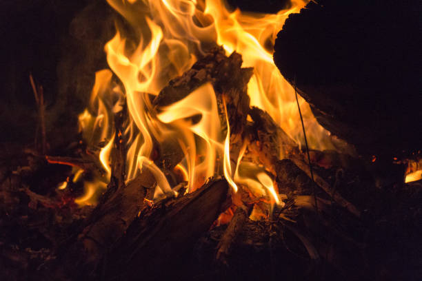 The view of bright flames and fire blazing at night on black background.