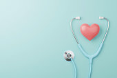 Top view of medical stethoscope and heart on cyan background. Health care insurance concept. 3d rendering