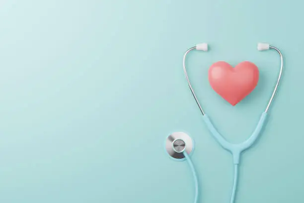 Top view of medical stethoscope and heart on cyan background. Health care insurance concept. 3d rendering