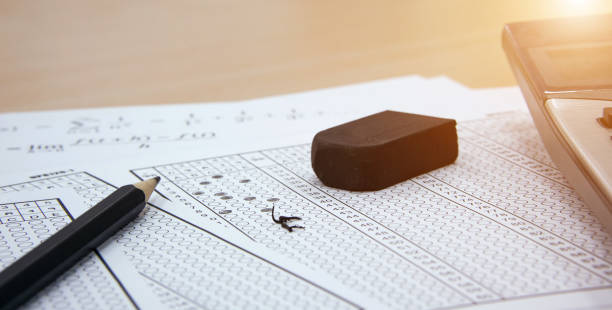 istock Answer sheet, pencil and eraser with exam question paper. 1386997848