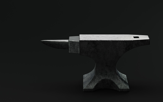 Anvil and a hammer on an industrial background, high angle view.