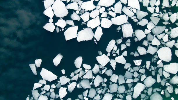 kayak che naviga tra banchi di ghiaccio sul lago. - ice floe foto e immagini stock