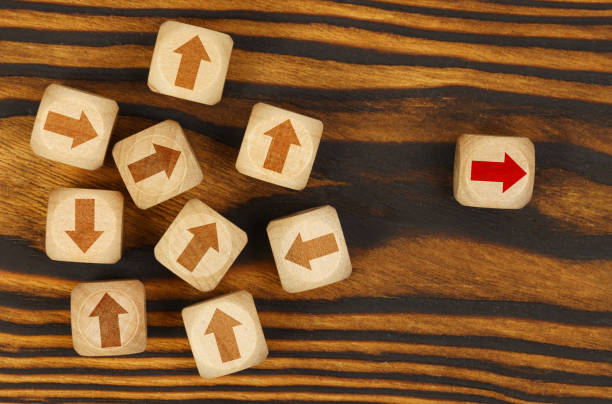 istock On a brown background, cubes with arrows, one cube with a red arrow to the side. 1387005834