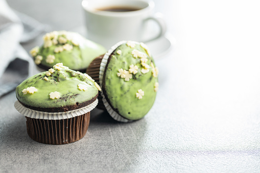 Sweet muffins with pistachio icing. Sweet dessert on a kitchen table.