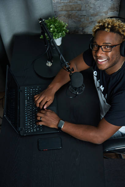 istock Black blogger with professional microphone records program for radio broadcast 1387012239