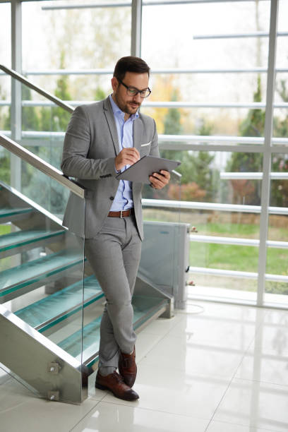 Businessman using digital tablet in an office building lobby stock photo