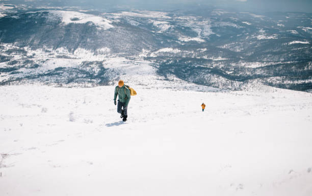 istock Hikers climbing snowy mountain 1387014618