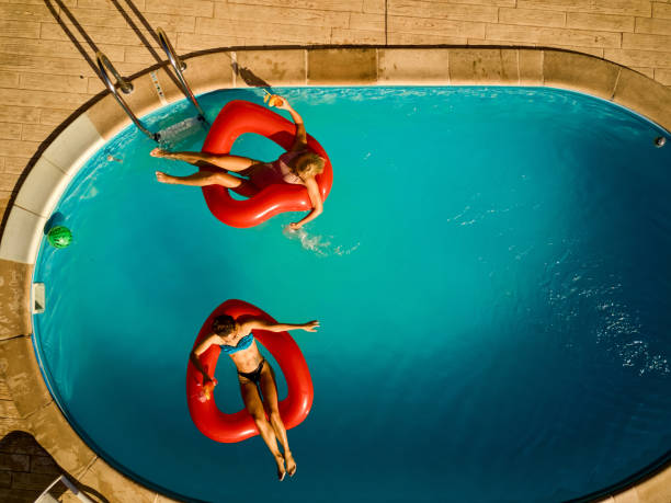istock Young women relaxing in a swimming pool 1387014686