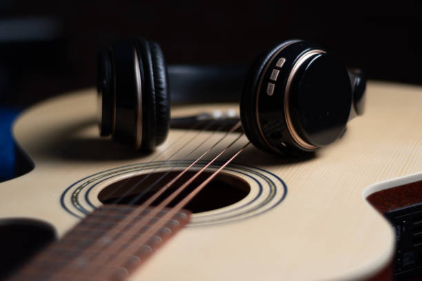 Detail of headphones harassed by an acoustic guitar