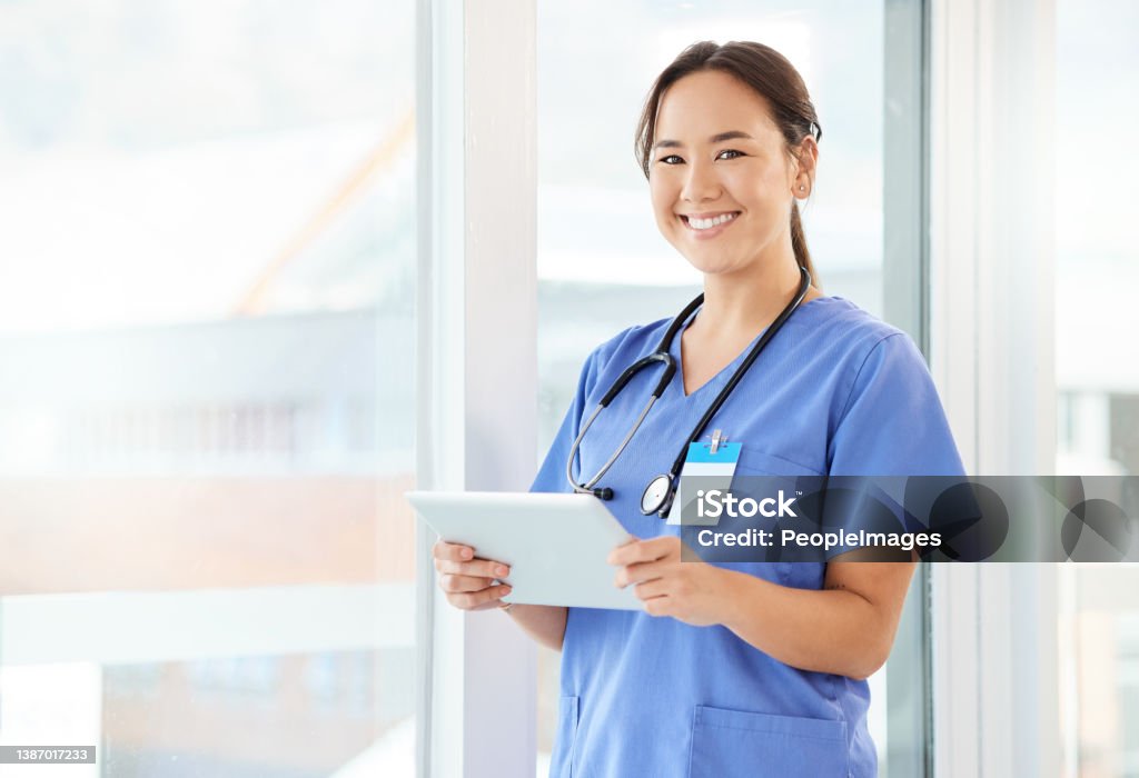 Shot of a young nurse using a tablet in a office They are young but they are experienced Nurse Stock Photo