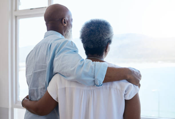 Shot of a couple looking at view in a house Two peas in a pod arm around stock pictures, royalty-free photos & images