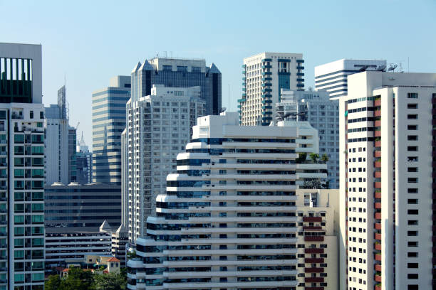 Cityscape view of Bangkok with tall buildings over sunny blue sky in Thailand