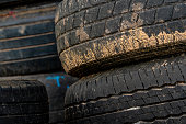 Stack of old tires. Pile of used tires. Black rubber tire of car. Dirty used tyres. Closeup old tyres waste for recycle. Closeup tread of an old dirty tyre. Change car tire for safety concept.