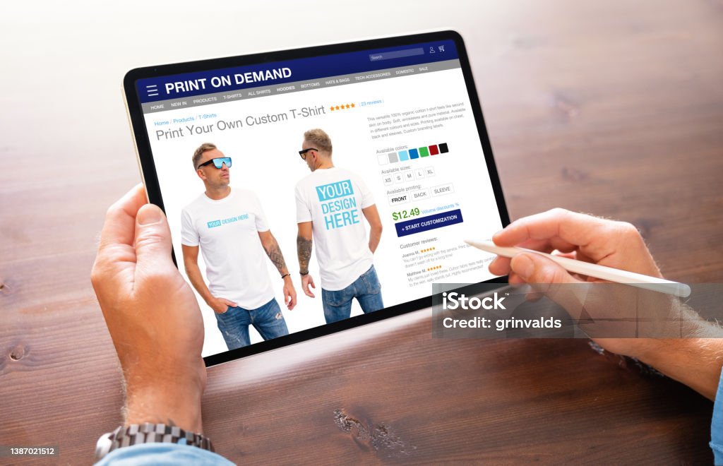 Man creating custom design t-shirt on print on demand service website T-Shirt Stock Photo