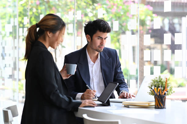 istock Two successful young entrepreneurs discussing on new project together at bright modern office. 1387023573