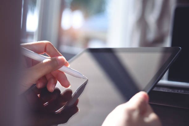 istock Woman using stylus pen on digital tablet computer, close up 1387033696