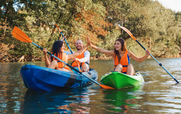 kayak à la rivière. un groupe d’amis heureux sont assis dans des kayaks. concept de la journée mondiale du tourisme - kayaking photos et images de collection