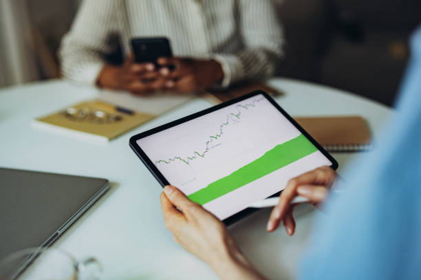 istock Unrecognizable Business Woman Analyzing Graph on Digital Tablet Screen at Office Desk 1387035327