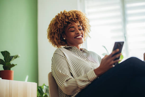 Happy Businesswoman Using Mobile Phone in the Office stock photo