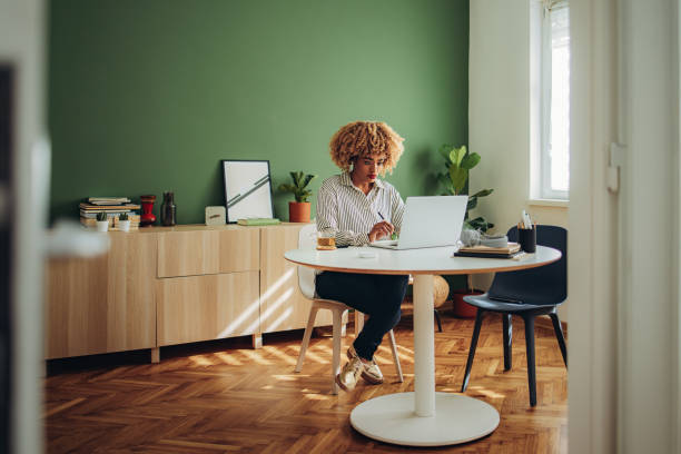 femme d’affaires travaillant sur son ordinateur portable dans un bureau moderne - desk on the phone sitting table photos et images de collection