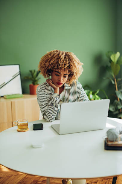 femme d’affaires travaillant sur son ordinateur portable - desk on the phone sitting table photos et images de collection