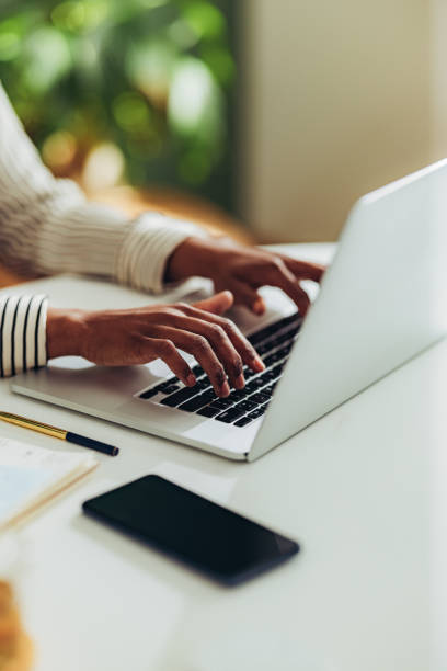 close up photo of woman hands using laptop computer in the office - typing imagens e fotografias de stock