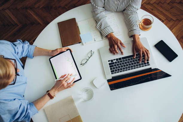 istock Two Unrecognizable Business Woman Working Together at Office Desk 1387035488
