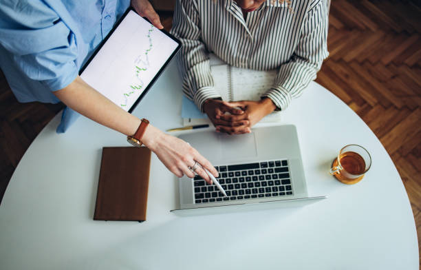 istock Two Unrecognizable Business Woman Working Together at Office Desk 1387035496