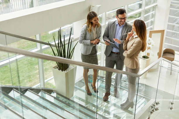 istock Young business people discussing ideas over digital tablet on staircase 1387038795