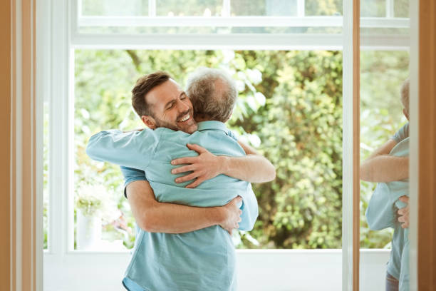 istock Happy man with eyes closed hugging father at home 1387039244