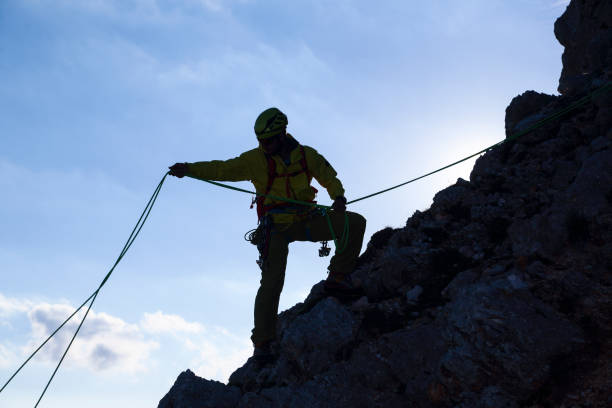 istock Silhouette of a mountain climber on a rock 1387040461
