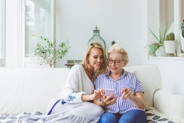 istock Daughter and mother using smart phone at home 1387040522