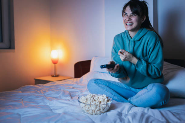 istock Woman eating popcorn while watching TV 1387040589