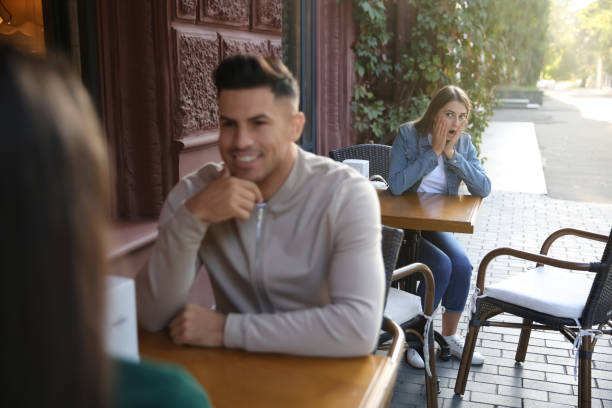 Jealous ex girlfriend spying on couple in outdoor cafe Jealous ex girlfriend spying on couple in outdoor cafe jealous ex girlfriend stock pictures, royalty-free photos & images