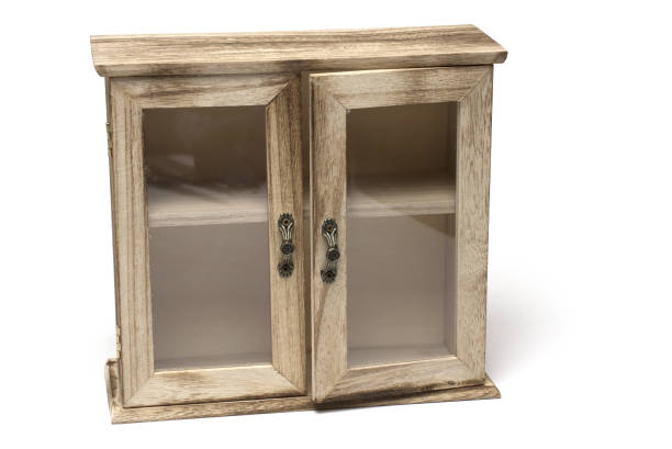 Close-up of decorative small wooden box cabinet with framed glass doors and metal handles on white background