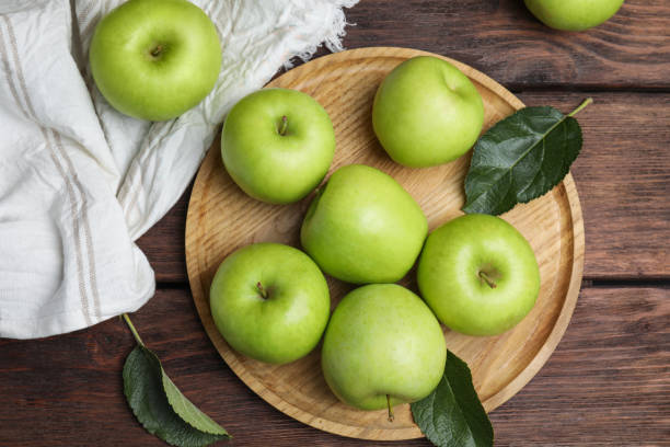 istock Fresh ripe green apples on wooden table, flat lay 1387045834