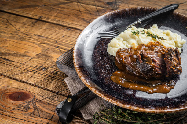 istock Beef cheeks stewed in red wine sauce with mashed potatoes. Wooden background. Top view. Copy space 1387049766