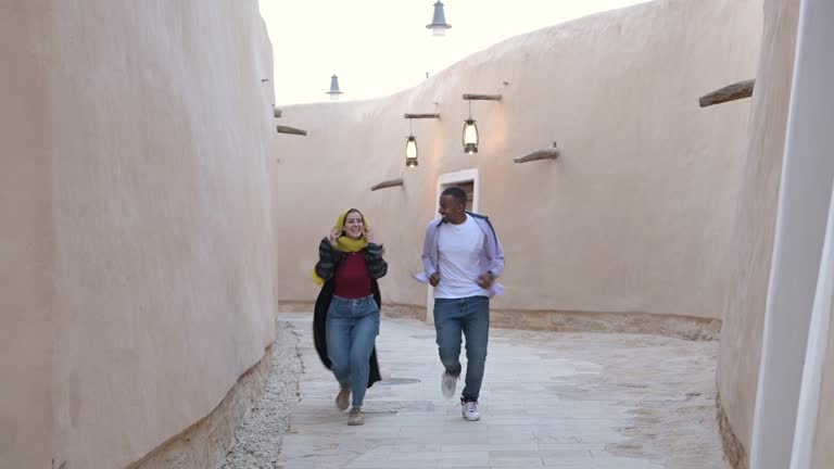 Playful tourists running on pathway leading through open air museum