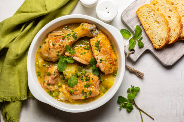 frühlingshühnerauflauf aus kartoffeln, lauch, grünen erbsen, weißwein und frühlingsgemüse, minze und frühlingszwiebeln. draufsicht. - kartoffelauflauf stock-fotos und bilder