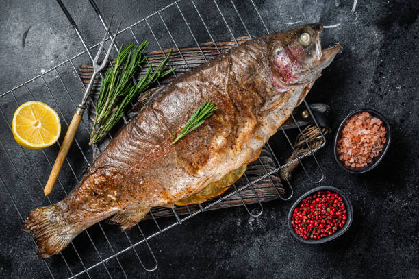 바베큐 구운 바다 송어, 로즈마리와 그릴에 구운 생선. 검은 색 배경. 위쪽 보기 - trout prepared fish whole grilled 뉴스 사진 이미지