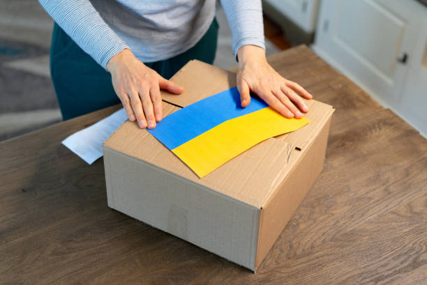 An unrecognisable person is closing a donation box . Help for people in need in Ukraine