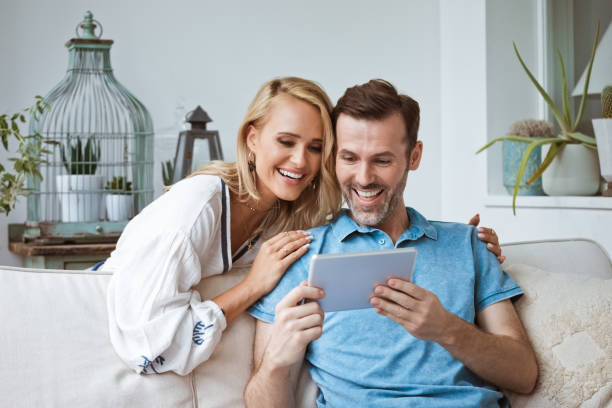 istock Happy couple looking at digital tablet 1387054272