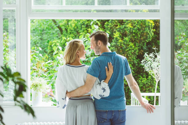 istock Happy couple near window at home 1387054332